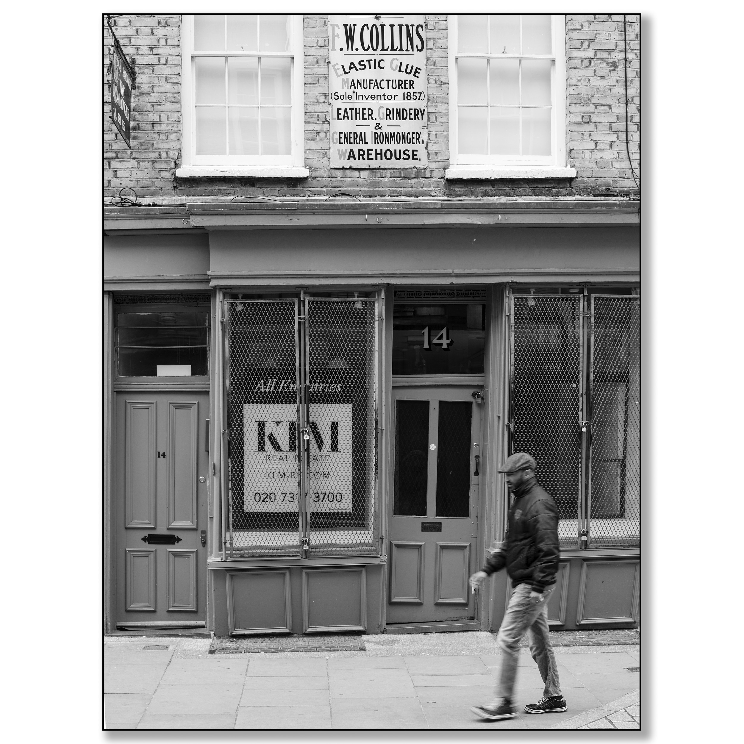 London Brick Lane, man walking in front of 19th age building