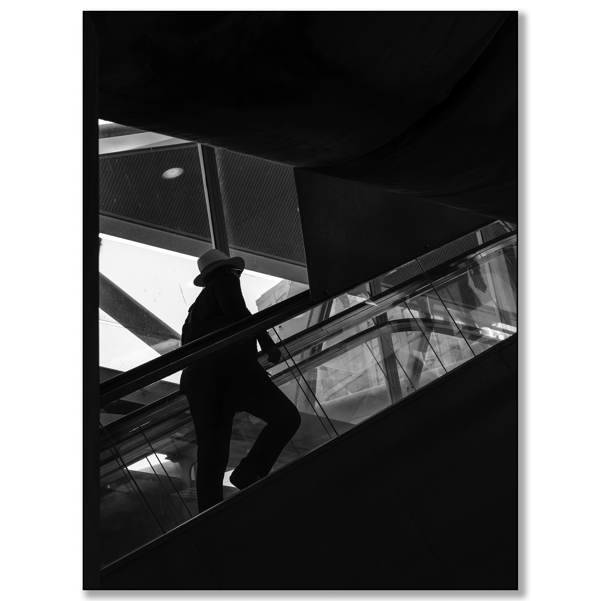 Man met hoed in silhouet op roltrap
